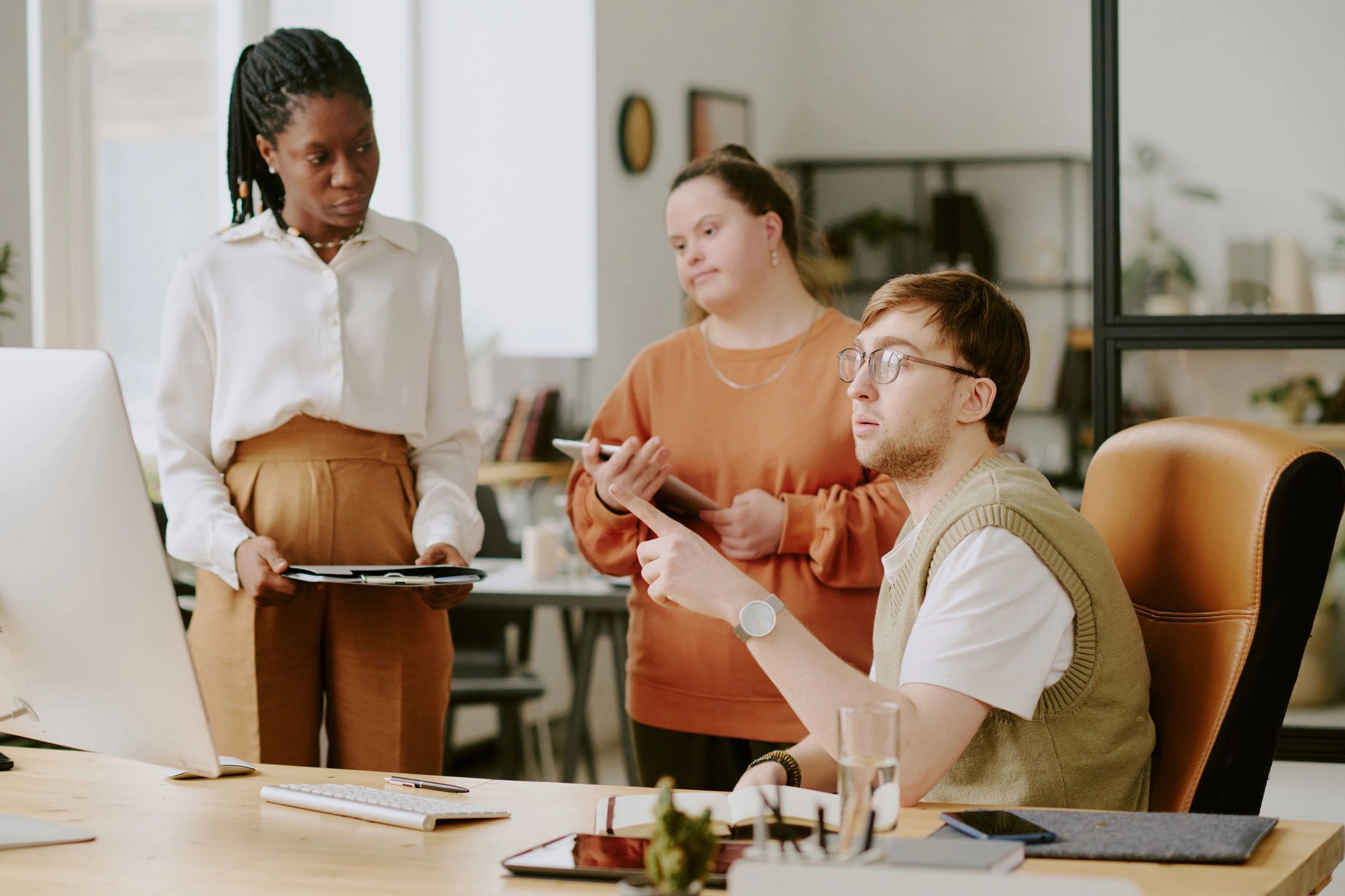 Professional team discussing plans around a computer
